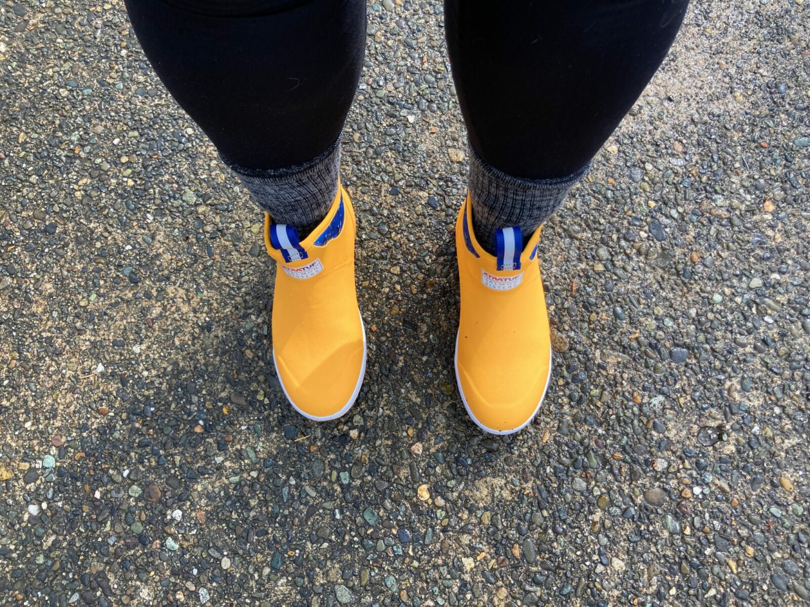 A person's feet wearing a pair of yellow boots in Seattle in winter