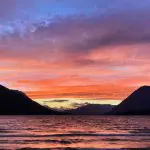 A pink and orange sunset behind distant mountains at Lake Wenatchee