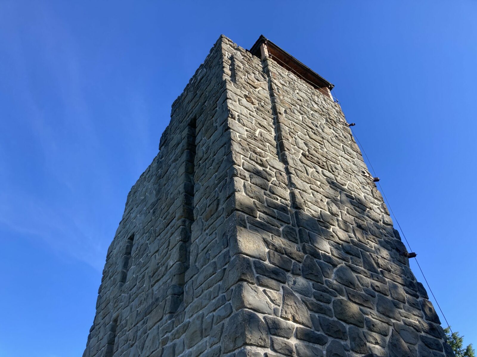 A stone observation tower at the summit of Mt Constitution, a popular Orcas Island hike. It's made of stone and has narrow openings on the side and a wooden platform on top