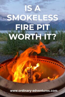 A fire pit with a roaring fire inside near the beach with mountains in the distance at dusk. Text reads: is a smokeless fire pit worth it?