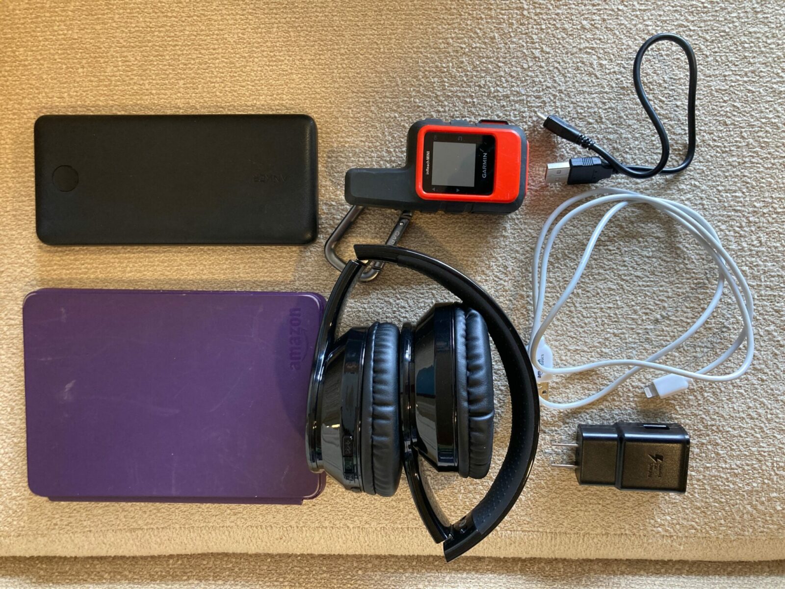 devices handy for travel in Alaska - a kindle ereader, back up battery supply, bluetooth headset, garmin in reach mini and charging cables