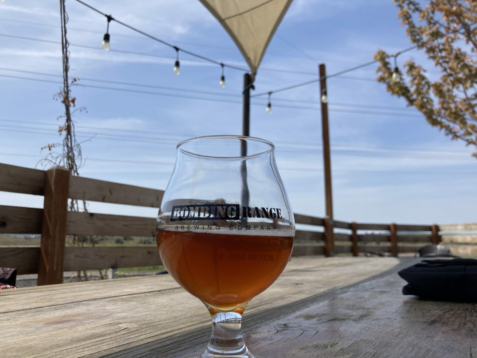 A beer in a round glass on a table on a patio in Tri-Cities.