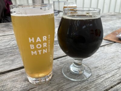 Two beer glasses, one tall with light beer and the other round with dark beer.