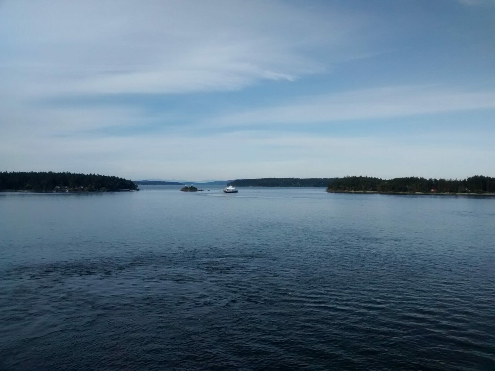 Two BC ferries in the narrow water between islands in the Salish Sea between Vancouver and Victoria