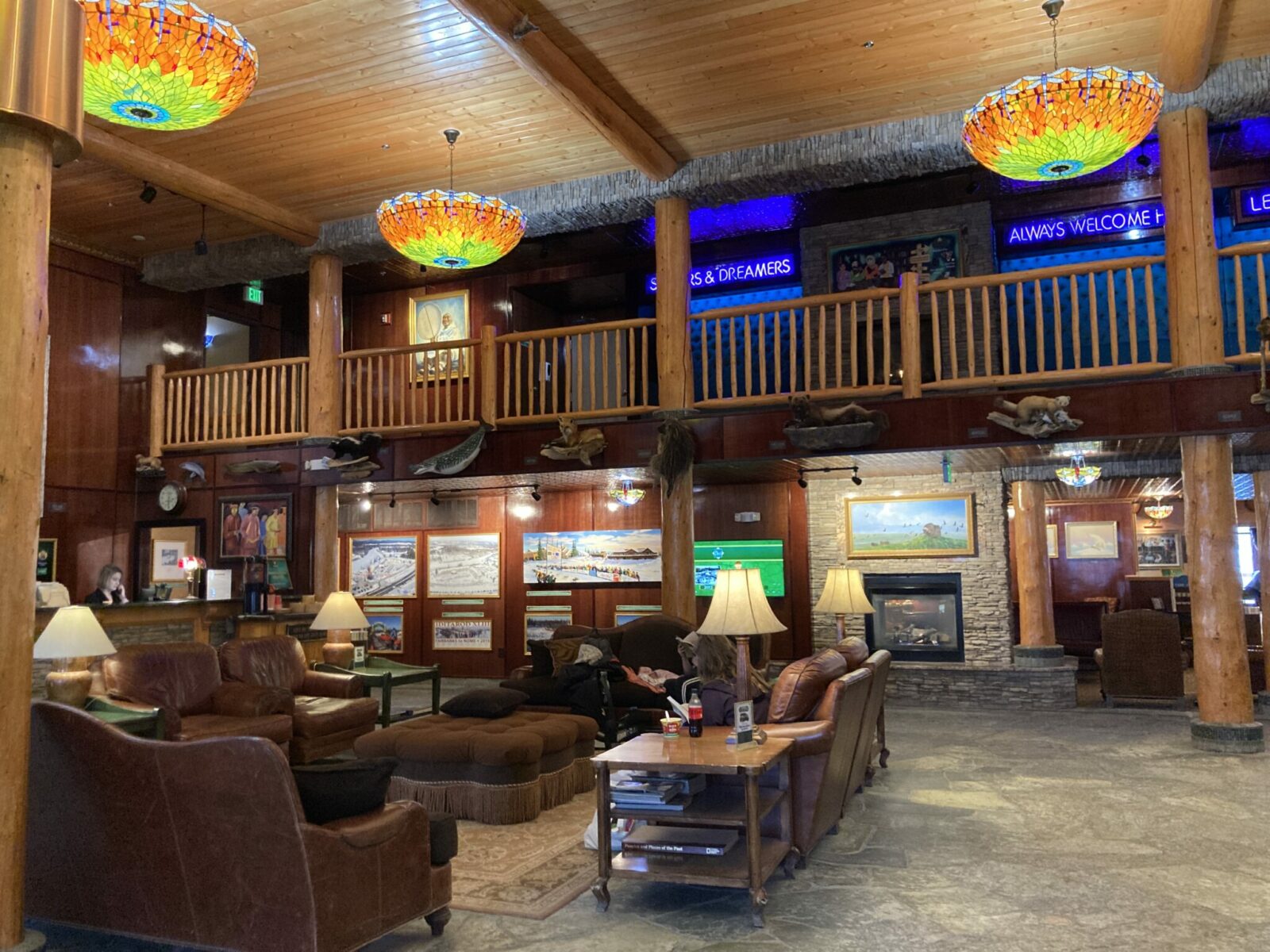 The lobby of Pike's Waterfront Lodge in Fairbanks. The lobby has an Alaskan decor with colorful lamps, log railings and comfortable couches with art from around Alaska on the walls