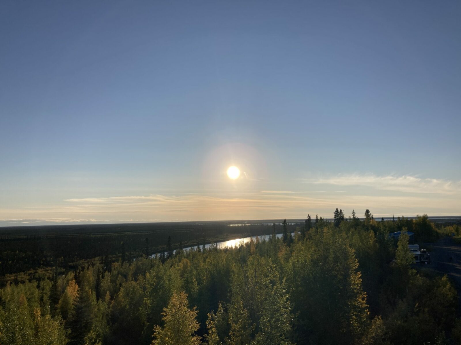 Low sun over a river and a forest