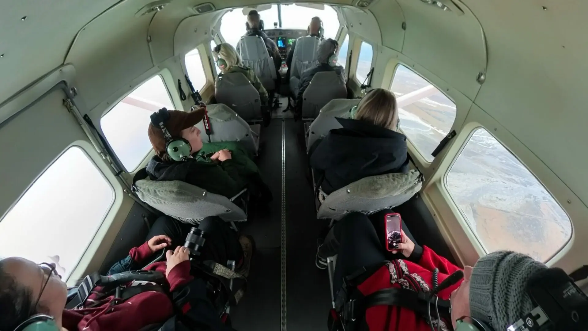 The interior of a floatplane seen from above through a fisheye lense. There are 8 seats for passengers plus the pilot and copilot seat.